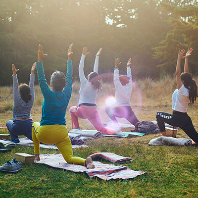 Women lungeing during group yoga class in nature