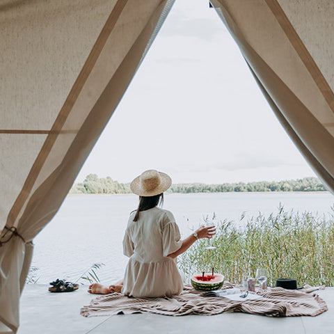 Woman eating at entrance of glamping tent