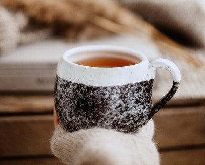 hand holding warm cup of tea