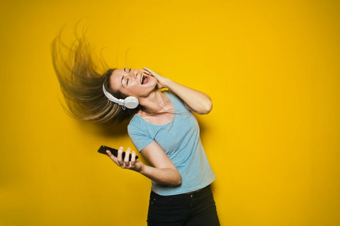 Girl-listening-to-music-with-headphones-on-dancing-and-singing