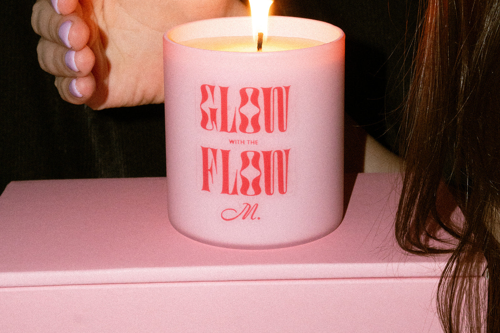 Moxie soy wax candle in a pink jar with 'Go with the flow' red text on the front