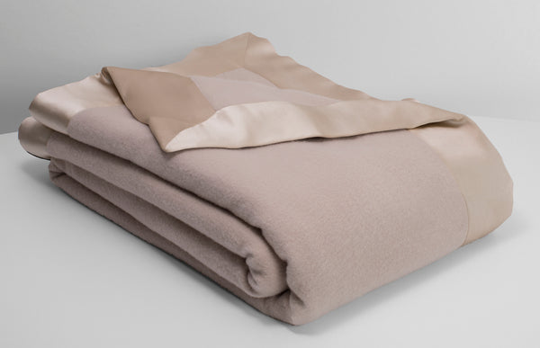 Henry cashmere and lambswool blend blanket in champagne beige lying neatly folded with an off white background