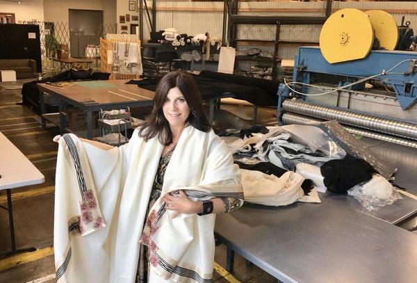 Founder JG Switzer in her workshop in California USA with Now Voyager luxury throw blanket in white wrapped around her