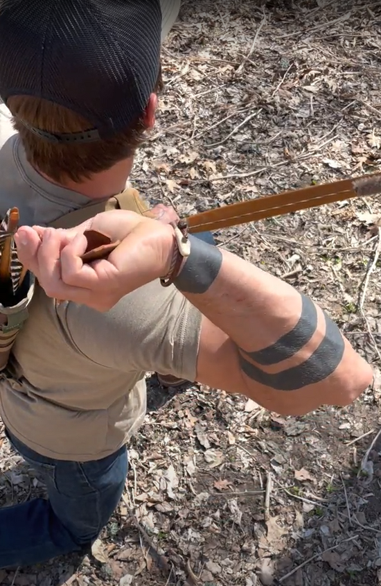 Correy drawing an arrow for his bow