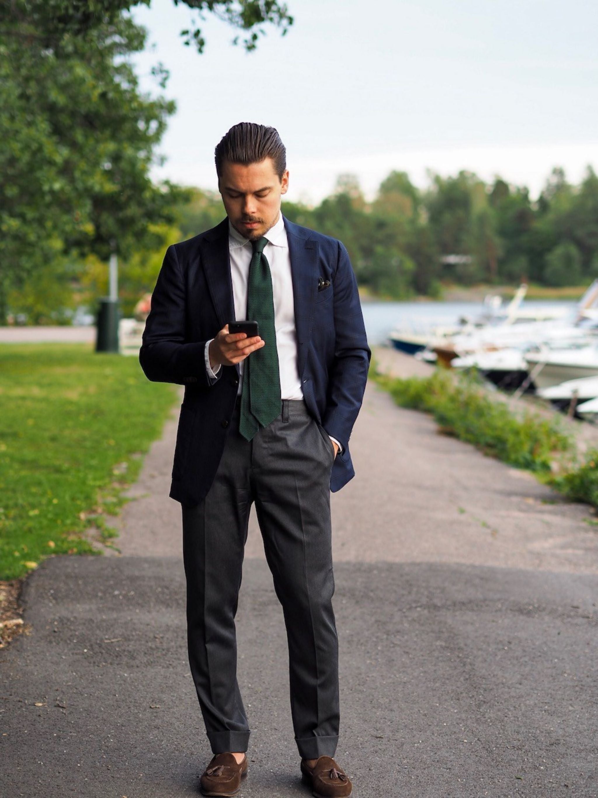 Green grenadie tie with navy blue suit jacket and gray flannel trousers