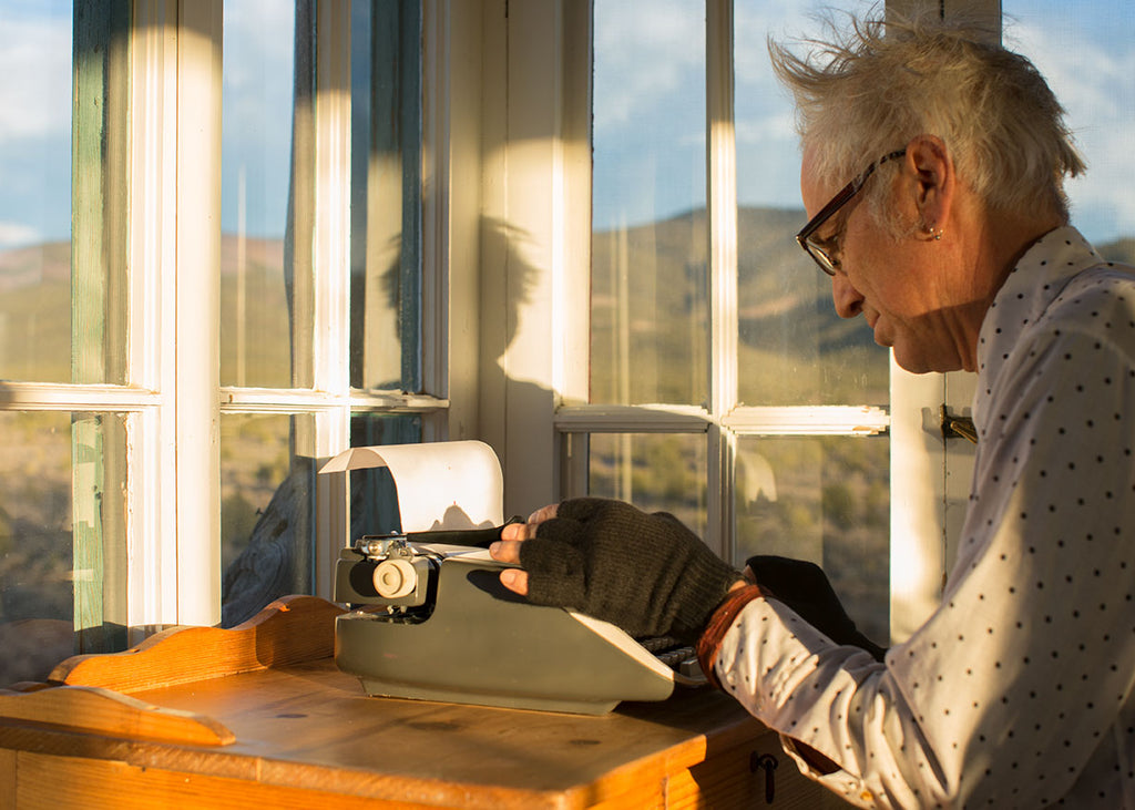 David Costanza on a typewriter in the writing room of the Mabel Dodge Luhan House with the Fingerless Gloves