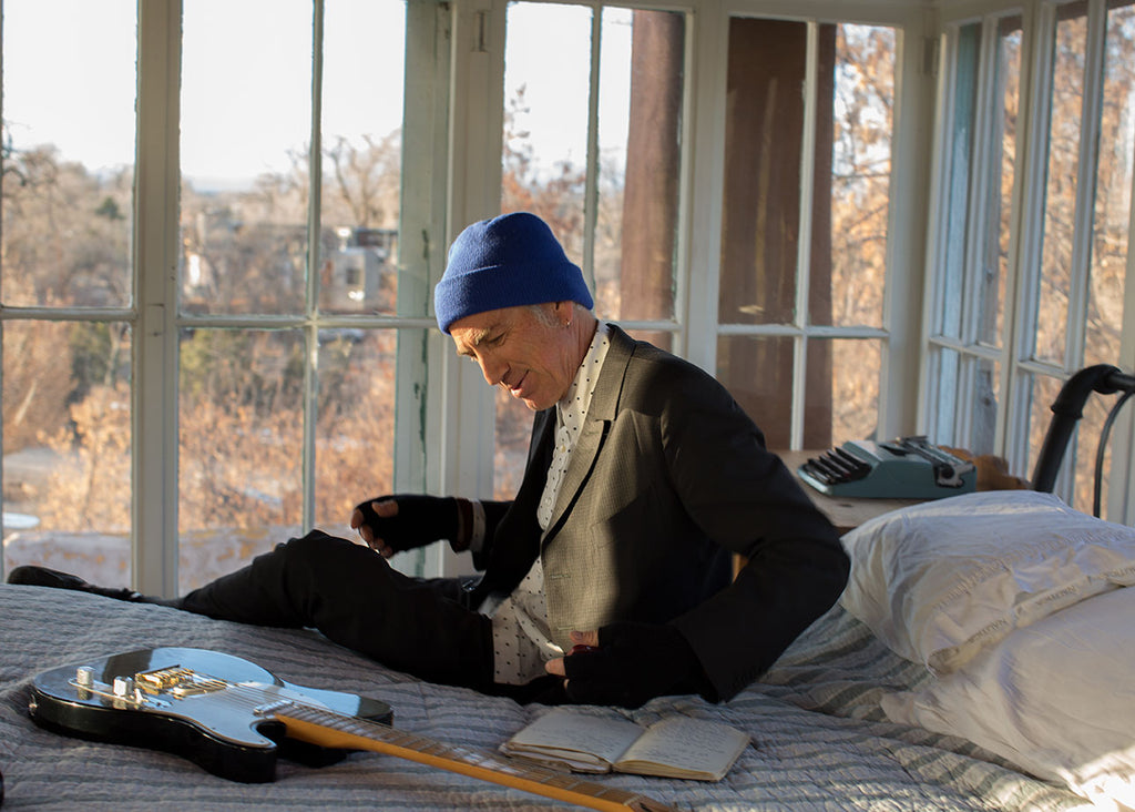 Taos musician David Costanza with his guitar and Cashmere Watchcap at the historic Mabel Dodge Luhan House