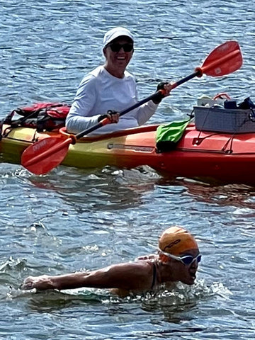 Adrienne in the water swimming fly with Lisa in the kayak