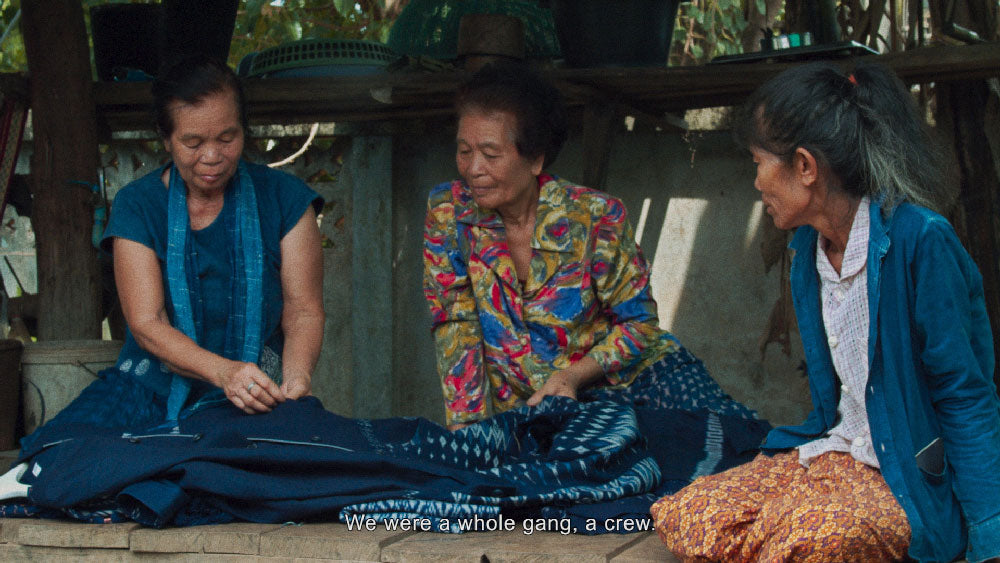 three indigo grandmas looking at ikat indigo fabric