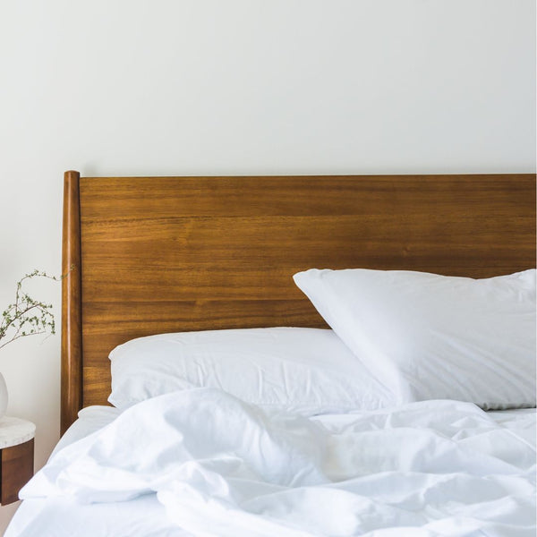 wood bed with white sheets