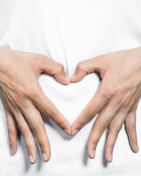 hands making a heart over gut