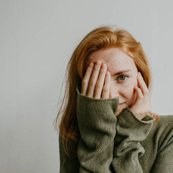 woman covering face with hand