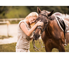 Woman hugging her horse and smiling