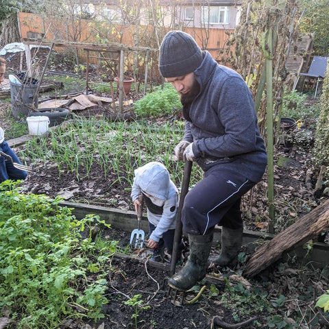 Mothin with his child, digging a raised bed in the garden