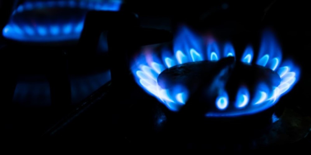 An image of an electric gas stove being switched on with a blue flame