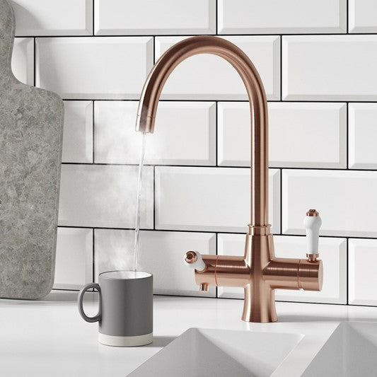 Copper boiling water tap in a kitchen with white metro tiling