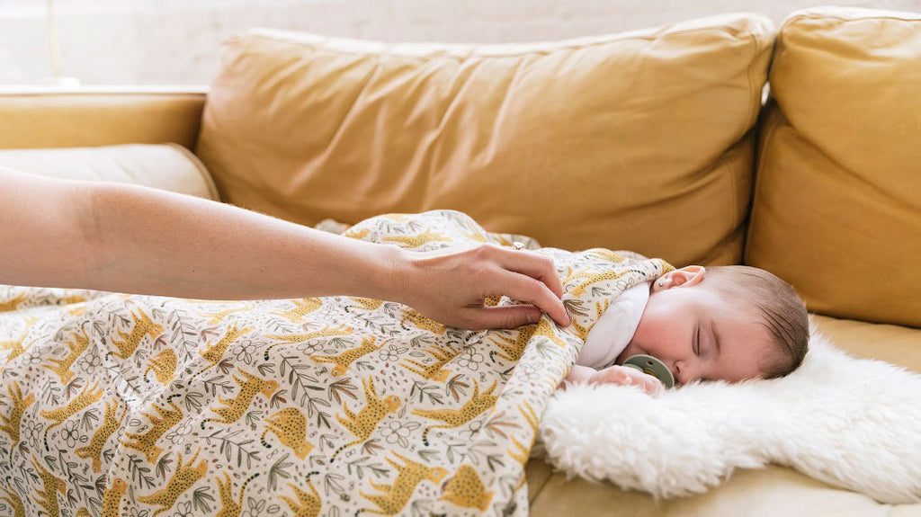 Un bébé qui dort recouvert de la couverture pour bébé Tula Prowl