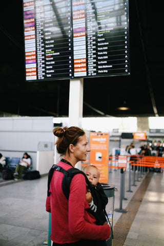 Mum with her baby in a Tula baby carrier walking through an airport