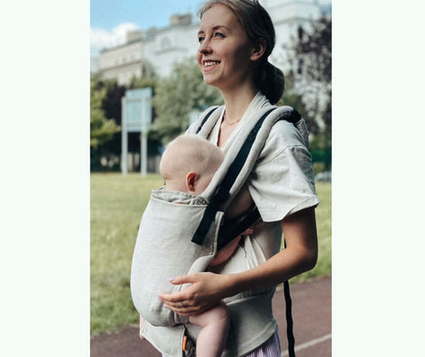 Agnieszka sta allattando suo figlio nel suo marsupio Tula Free-to-Grow 