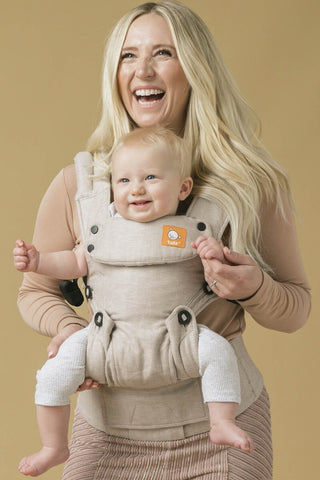 Eine Mutter und ihr Kind benutzen ein Babytrage von Tula in vorwärtsgerichteter Position.