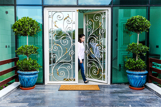 Young lady walks through a wrought iron door