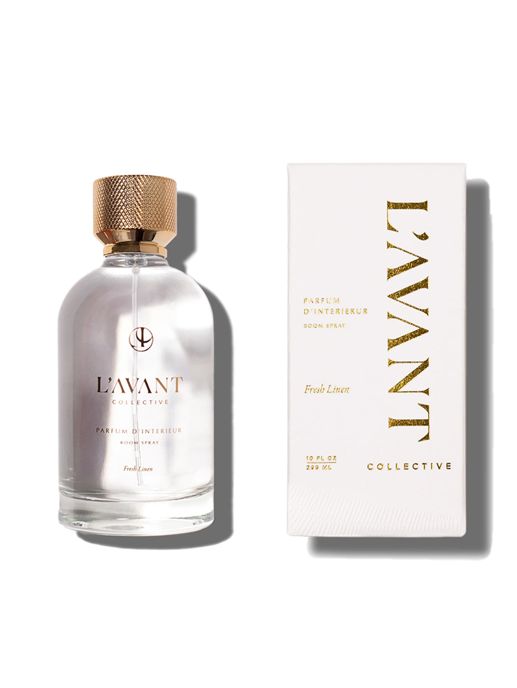 Clear glass bottle with L'AVANT logo stamped in gold foil. White retail box with L'AVANT Collective brand stamped in gold foil.