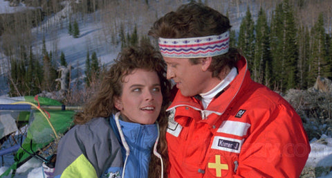 a man and a woman are outside on a snowy mountain, both wearing warm snowsuits