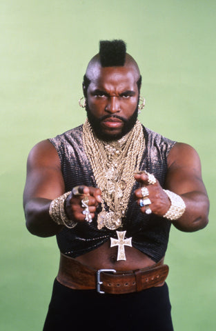 mr. t wearing a black tank top and many gold necklaces, and a leather belt