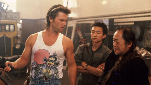 jack burton wearing a fu manchu tank top and talking to two men