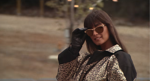 a woman wears a stylish silver and black snow jacket with shades