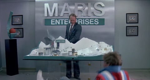a businessman stand in front of a model of a ski resort