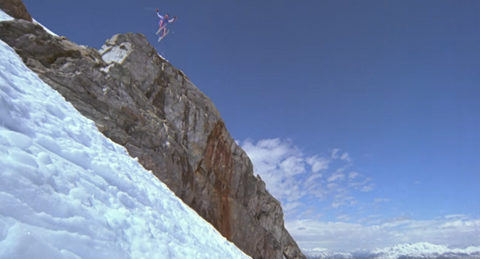 a skiier takes a huge leap off a cliff