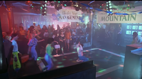 a big party at a bar with people running onto the dance floor