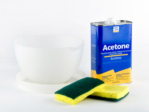 a plastic bowl, two sponges, and a container of acetone