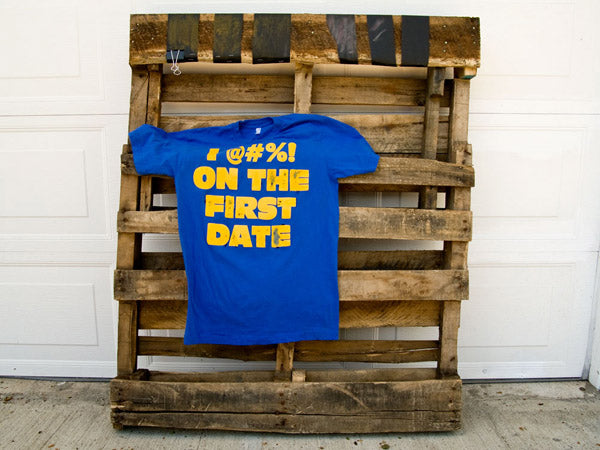 a blue t-shirt hanging on a wood pallet