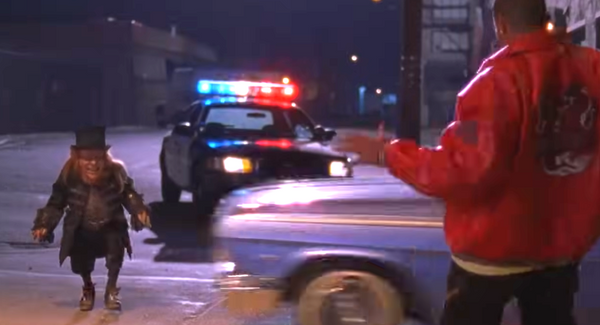 a leprechaun stands in front of a police car