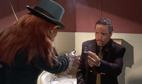 Ice-T passes a joint to a leprechaun in a bathroom