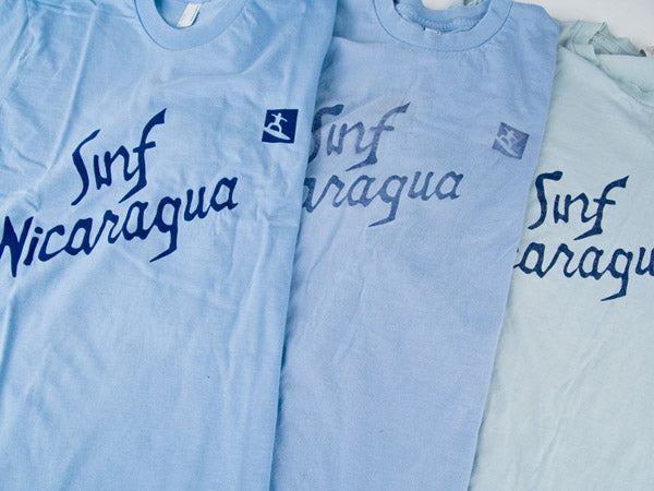 three blue surf nicaragua t-shirts, one is new and two are faded