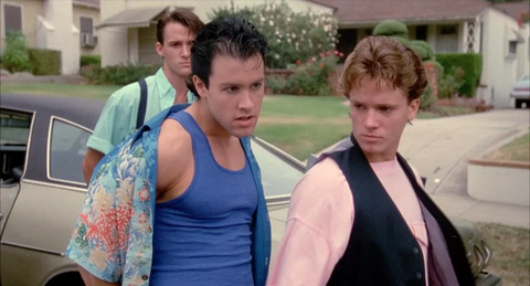 two teenage boys stand on a suburban street looking tough