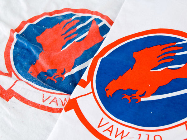 two white t-shirts with red and blue screenprinting, one is faded and one is new