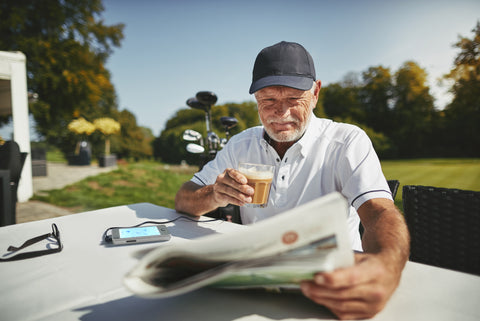 A man reading the paper while using the NuroKor Lifetech mitouch