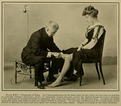 Image of man using electrotherapy on a lady's knee from a book published in 1910