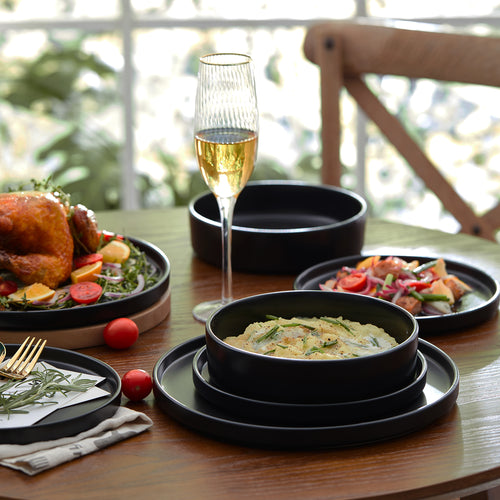 Celina Stone Lain serving platters set up on a holiday table setting with varying sized plates filled with food.