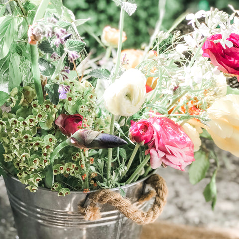 Bucket of country flowers on the doorstep of a country cottage
