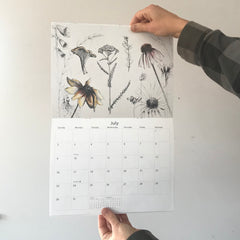 Raina McDonald holding her July calendar page