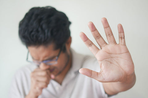 Man trying to stop coughing