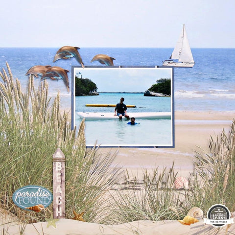 scrapbook page featuring single image of man and son sitting on a raft in an ocean cove. Image is surrounded by beachy embellishments