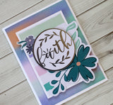 handmade card on watercolor background with the word faith in a large die cut circle and floral die cut embellishments