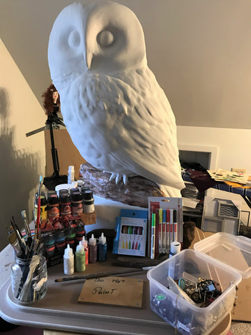 white 3D owl sculpture surrounded by art supplies before being decorated