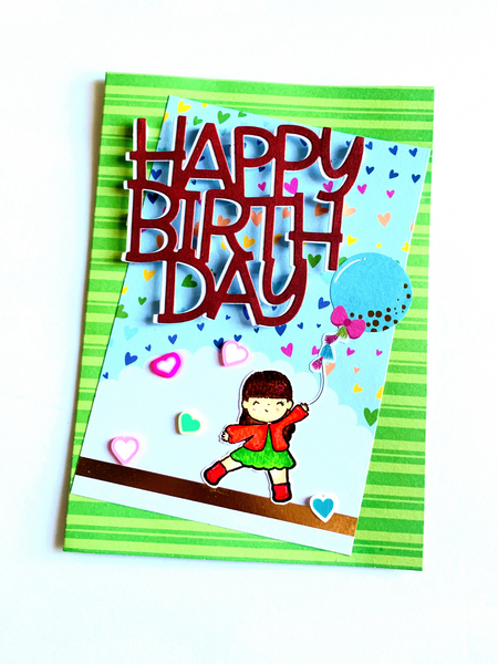 bright green birthday card with large HAAPY BIRTHDAY sticker and a stamped image of little girl holding a balloon